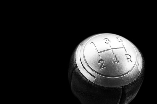 Close up view of a manual gear lever shift isolated on black background. Manual gearbox. Car interior details. Car transmission. Soft lighting. Abstract view. Car detailing