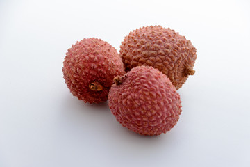 Lychee (LEE-chee; Litchi chinensis) is the sole member of the genus Litchi in the soapberry family, Sapindaceae. Three lychee is on a white background. Tropical fruit.
