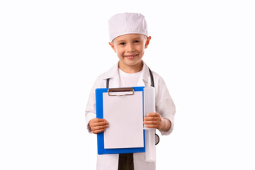 A  little, smiling boy doctor in  medical uniform, isolated on white, with stethoscope on the neck,  reminds you about health care and healthy lifestyle. Waist up portrait, looking at camera.