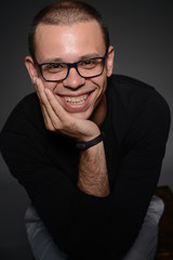 a man in a black jacket shows emotions in the Studio on a black background