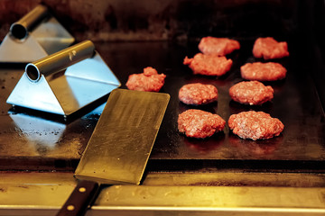 cooking burgers in the restaurant on the grill. the kitchen of fast food restaurant - obrazy, fototapety, plakaty