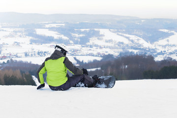 Guy snowboarder stand on the background of snow-capped mountains, preparing for slalom. Modern...