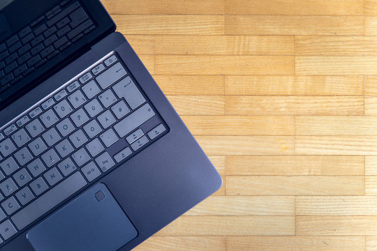 Modern laptop on the wooden floor, text space