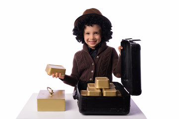 A little boy, 5 years old, plays with gold bars. He works in the bank as a security guard. The...