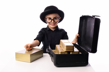 A little boy, 5 years old, plays with gold bars. He works in the bank as a security guard. The...