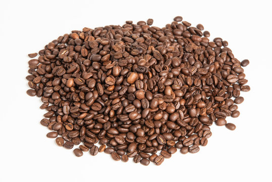 A mound of roasted and dried arabica coffee beans set on a white background in a horizontal image format.