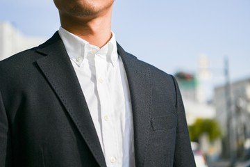 スーツ姿の空を見上げる男性