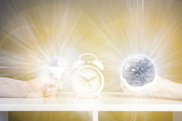 Obraz na płótnie Canvas hand hold earth near alarm clock. earth hour concept b