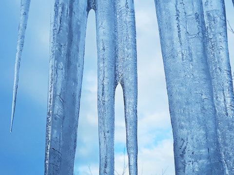 Textured icicles against a blue sky
