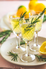 Liqueur limoncello with pieces of lemon and rosemary herb