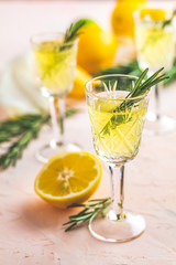 Liqueur limoncello with pieces of lemon and rosemary herb