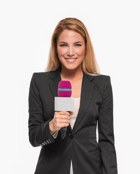 Attractive blonde TV presenter on white background holding a microphone and points to an object.