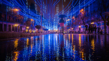 Calle de Alcala street downtown Madrid with Christmas decorations reflected on the floor on a rainy...