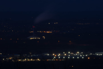 Factory with smoking chimney at night