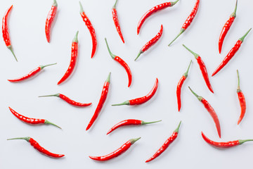 Flat lay red chili peppers pattern on white background.