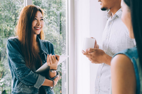 Young asian casual business team happy smiling and relax while meeting about marketing in modern coworking space office - Powered by Adobe
