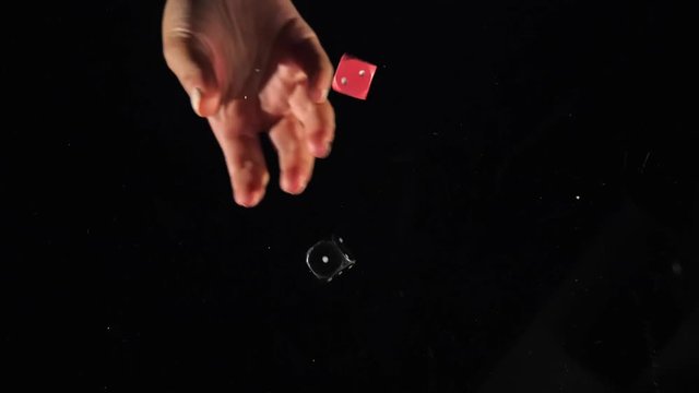Red dice rolling on casino table in slow motion