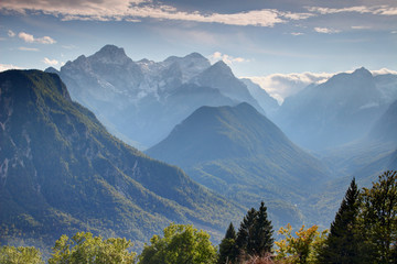 Steep forested walls of Vrata, Kot and Sava valleys in autumn haze with snowy Triglav and Rjavina peaks, Julijske Alpe range Triglav National Park Gorenjska Kranjska Carniola Slovenia Central Europe © nogreenabove2k