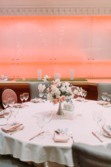 Decor, wedding tables in the restaurant. Floristry, arch and flowers in the design.