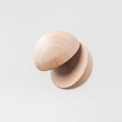 Abstract floating wooden half ball on white background