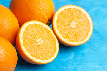 Halves and whole ripe orange citrus fruits on a blue background