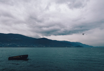 Lonely wooden boat in Ohrid Lake on cloudy day - 244249092