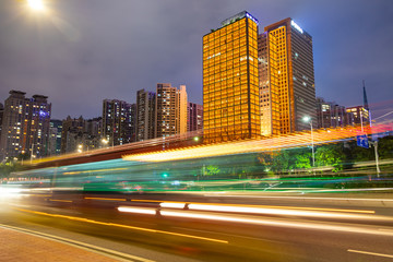 Fototapeta na wymiar Beautiful street at night with light trails in Guangzhou central business district. Image of blur motion of cars on the city road.