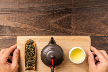 man's hand hold taiwan oolong tea and teapot
