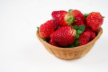 Fresh strawberries in a wooden bowl isolated on white