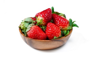 Fresh strawberries in a wooden bowl isolated on white