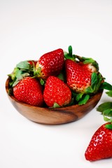 Fresh strawberries in a wooden bowl isolated on white