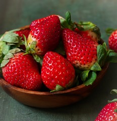 Fresh Strawberries in a wooden bowl on dark background