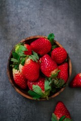 Fresh Strawberries in a wooden bowl on dark background