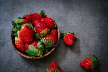 Fresh Strawberries in a wooden bowl on dark background