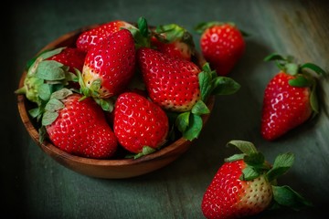 Fresh Strawberries in a wooden bowl on dark background