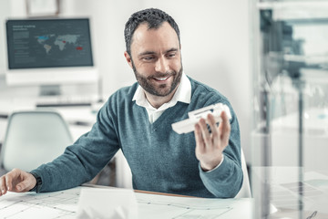 Joyful positive adult man smiling at work