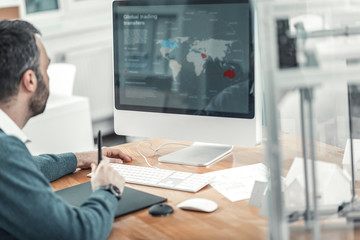 Serious nice man looking at the computer screen