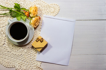 coffee with roses and gift on the rustic table