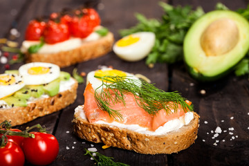 Set of different bruschettas on dark wooden table.