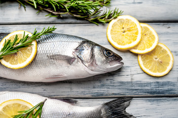 Fresh fish sea bass. Sea bass raw fish with ingredients spices and herbs on wooden background
