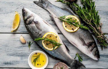 Fresh fish sea bass. Sea bass raw fish with ingredients spices and herbs on wooden background