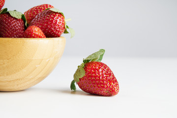 Fresh perfect berries red strawberries in a wooden plate on white, Concept of healthy eat food and nutrition..
