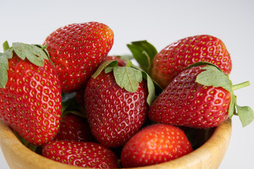 Fresh perfect berries red strawberries in a wooden plate on white, Concept of healthy eat food and nutrition..