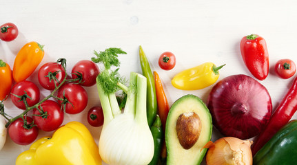 A bunch of fresh different seasonal green vegetables avocado, fennel, garlic, onion, tomato, red yellow peper from above. concept of healthy food and nutrition, space for layout.
