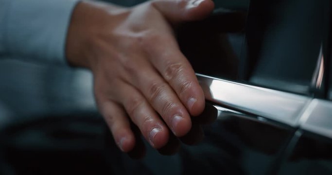 Close up young businessman checking anonymous just repaired in car auto body shop. Slow motion shot in 8K. Concept of auto deal, car dealerships, used cars, luxury cars
