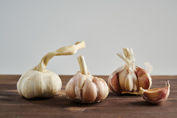 Fresh garlic on wooden background. Still life with raw vegetable. Concept of healthy food and nutrition.
