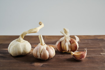 Fresh garlic on wooden background. Still life with raw vegetable. Concept of healthy food and nutrition.