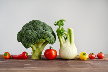 Fresh peper, fennel, broccoli, tomato on wooden background. Still life with raw vegetable. Concept of healthy food and nutrition.
