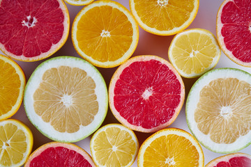 Fototapeta na wymiar Fresh citrus fruits orange, lemon, grapefruit, pomelo half-sliced from above, pattern for layout. concept of healthy eat food and nutrition, space for layout.