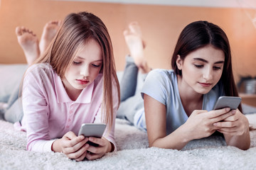 Focused two girls scrolling web pages down